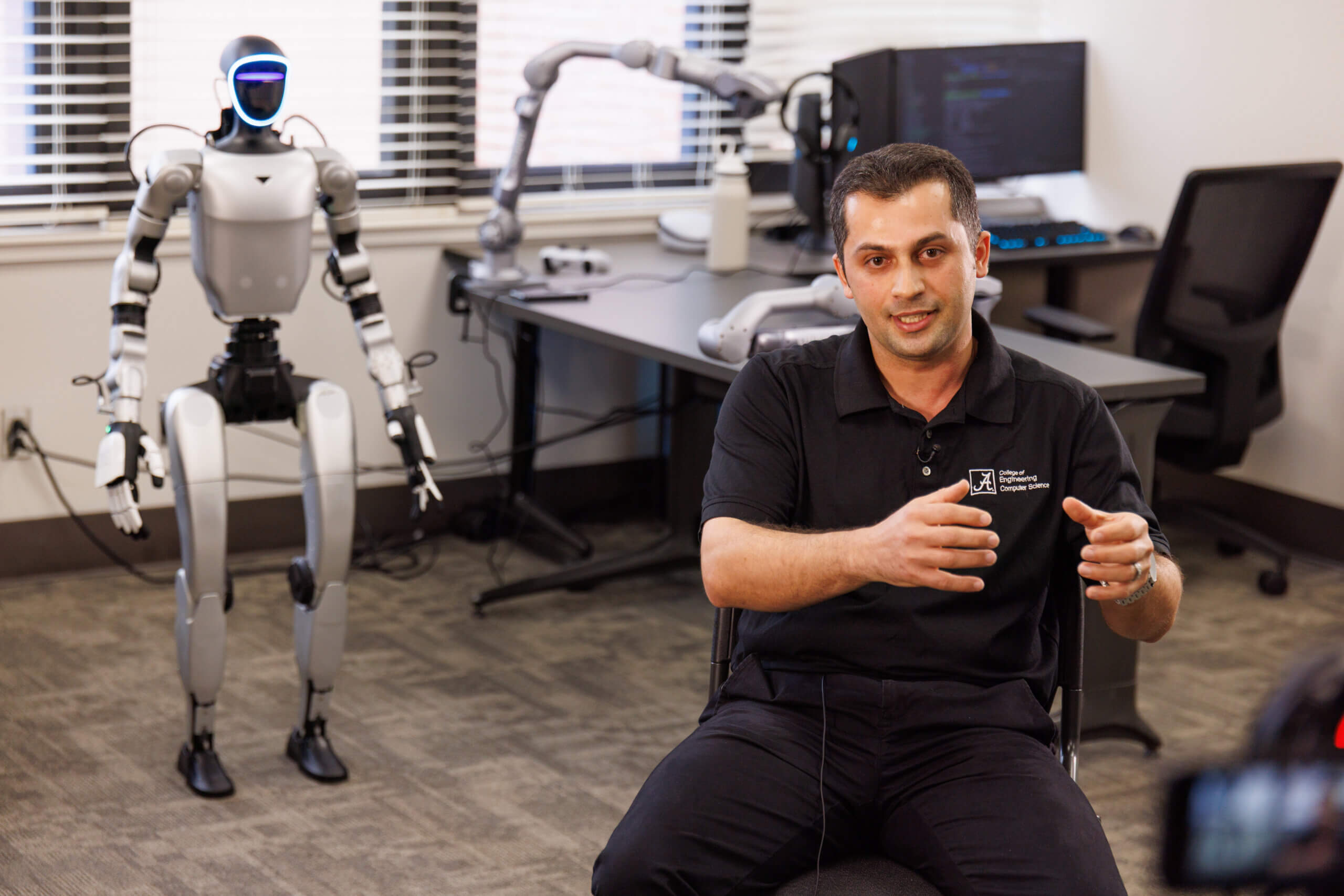 Dr. Noorbakhsh Amiri with a humanoid robot in The University of Alabama BRAINS Lab